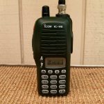 An Icom handheld aviation radio on a wooden table