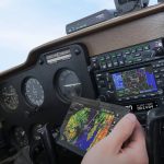 A pilot looking at an ADS-B receiver as he flies