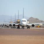 4 planes parked on a runway one after each other