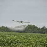 A commercial pilot flying over a field