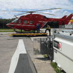 A red helicopter being refueled