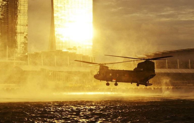 A military helicopter flying low over water