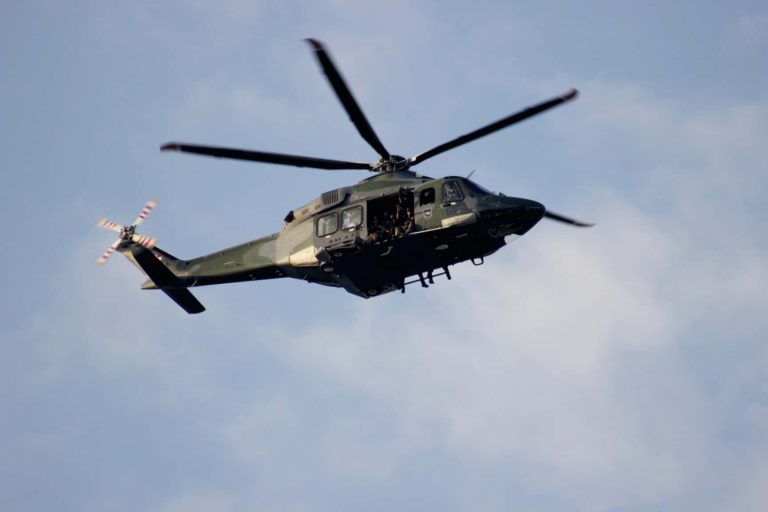 A mlitary helicopter generating a lot of noise as it flies