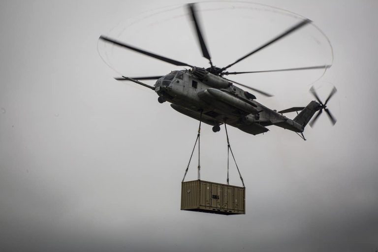A helicopter lifting a heavy container