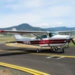 Cessna 172 plane on runway with mountains in the background
