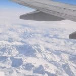 A plane flying over a snowy mountainous region