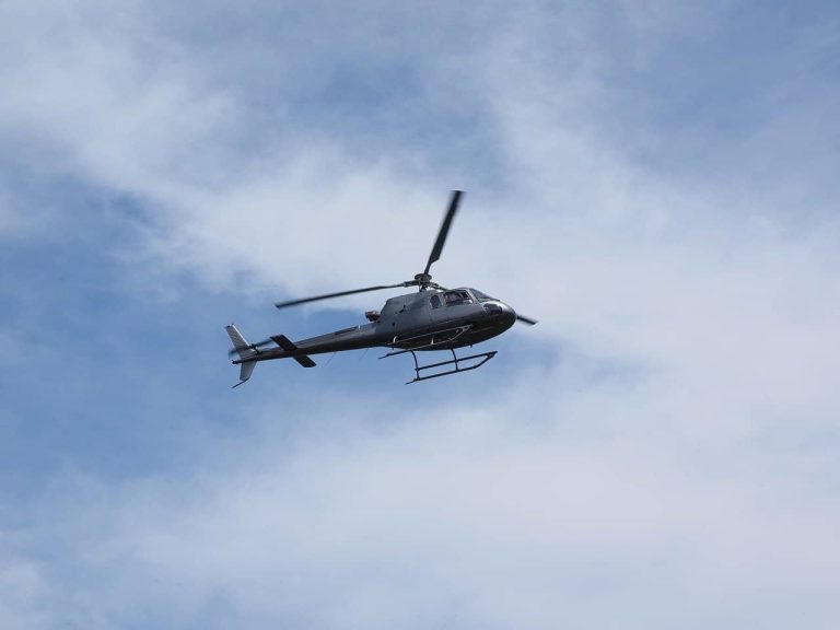 A mid-priced helicopter flying at a low altitude