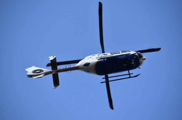 A commercial helicopter flying in blue skies