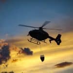 Comparing the Weight of Helicopters: Civilian, Police & Military A heavy helicopter flying as the sun sets