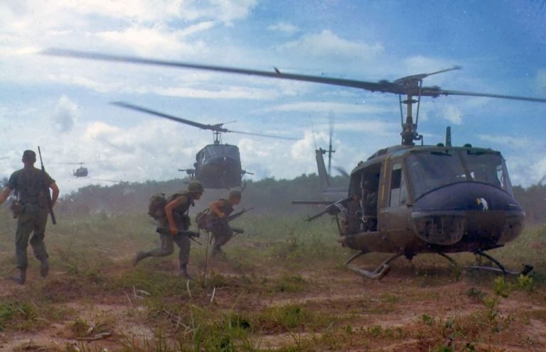 Soldiers rushing to a helicopter during the Vietnam War