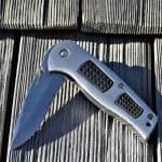 A half folded pocket knife on a wooden floor