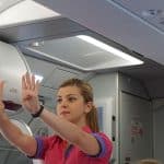 A flight attendant demonstrating safety instructions