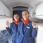 Two tall smiling flight attendants in uniform