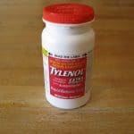 A bottle of extra strength Tylenol on a wooden table