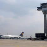 An air traffic control tower and plane in view