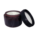 An open jar of lotion with its lid resting against it