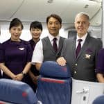 A purser and 6 flight attendants standing on a plane