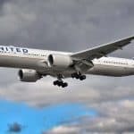 A white plane cruising in cloudy blue skies