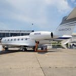 Private Jets vs. Commercial Planes: Which One Is Faster? A private jet parked on a runway in cloudy skies