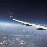 A plane's wing overlooking a city from above at night