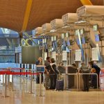 Passengers checking in bags at an empty airport counter