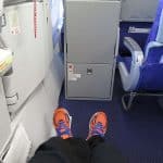 a passenger stretching his legs in an exit row seat
